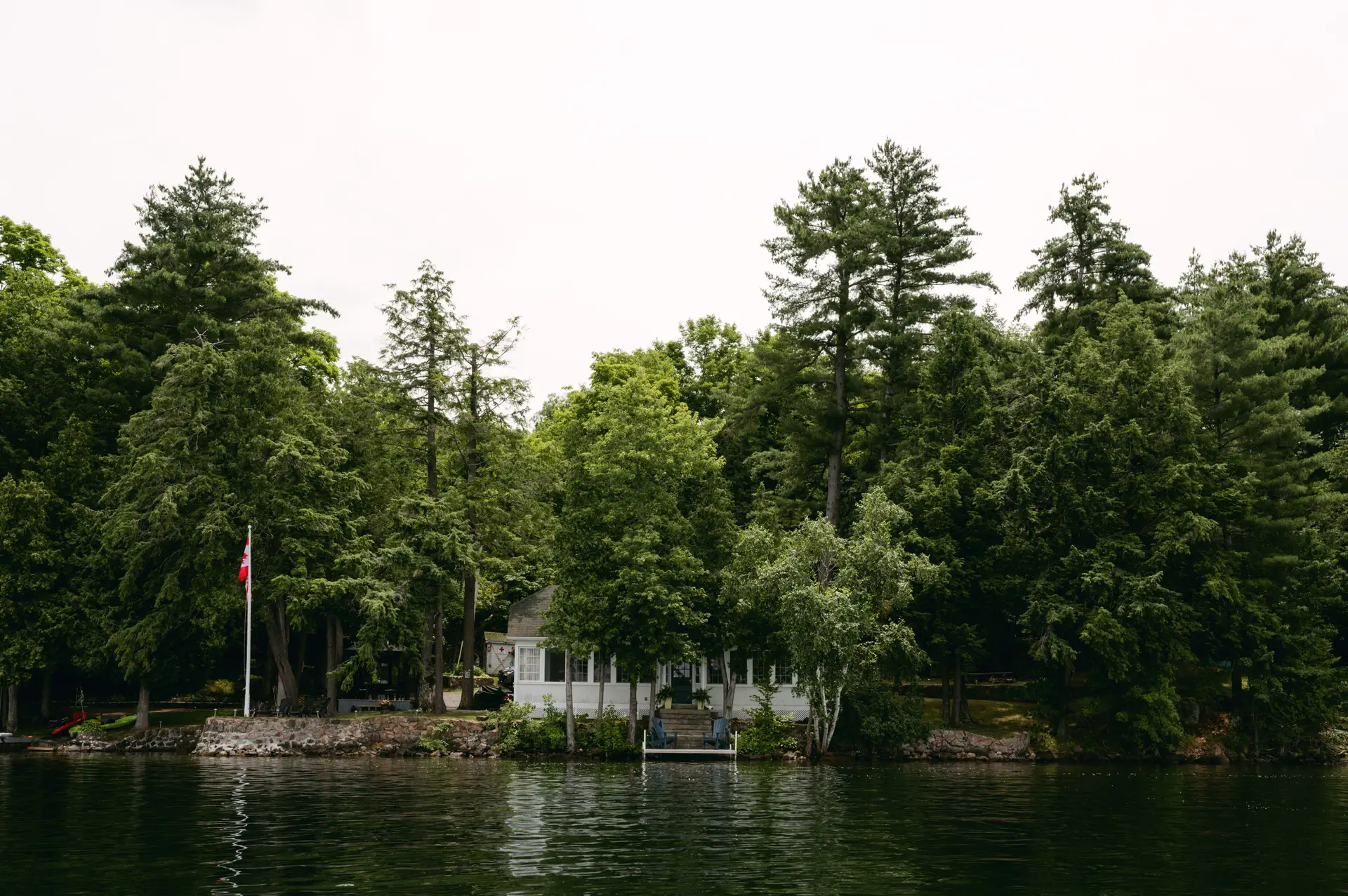 The Forest Sanctuary Suite exterior surrounded by moss-draped pines and still coastal lake water
